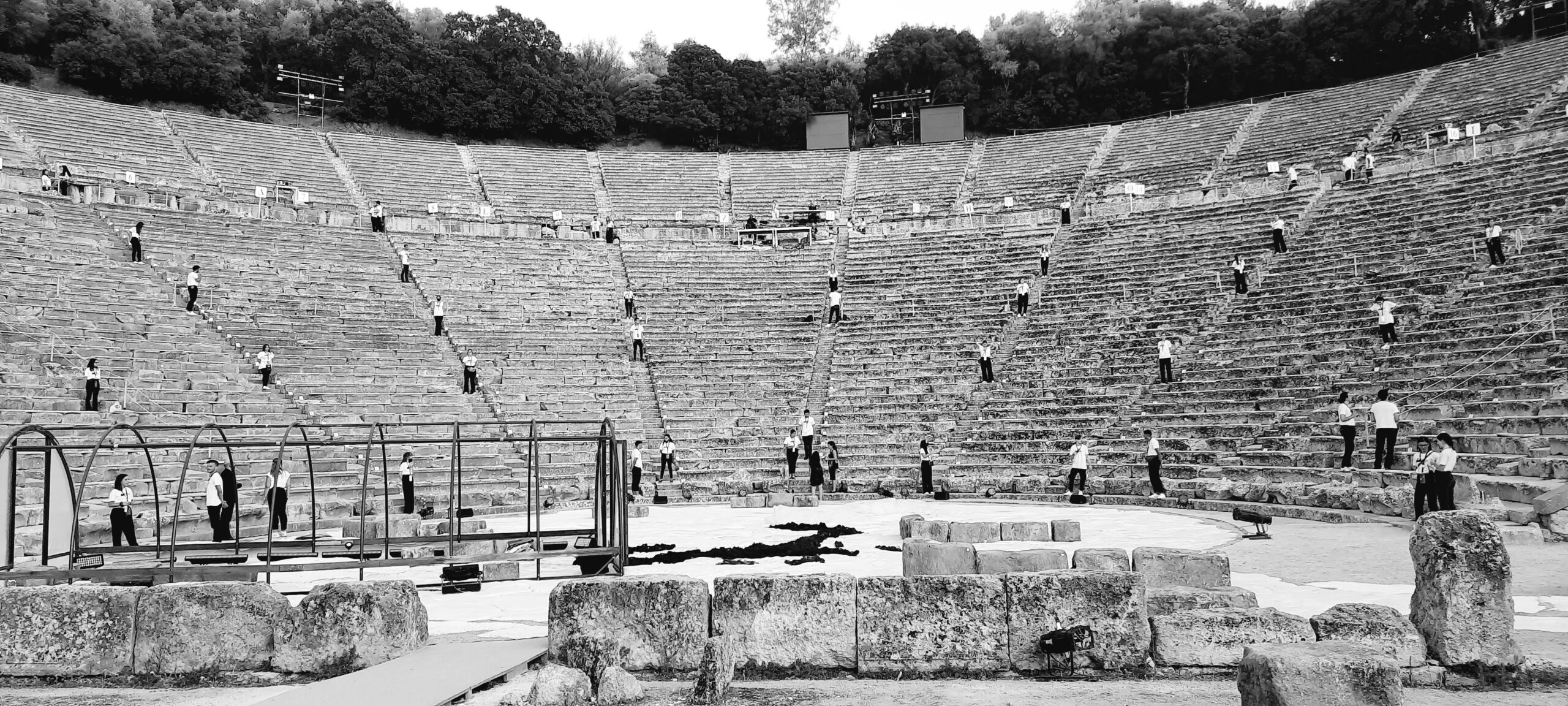 a group of people standing on a stone theatre of Epidavros